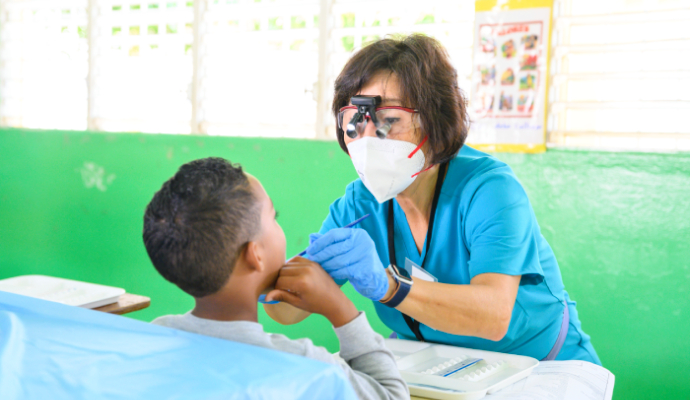 Envista employee performing dental assessment on mission trip