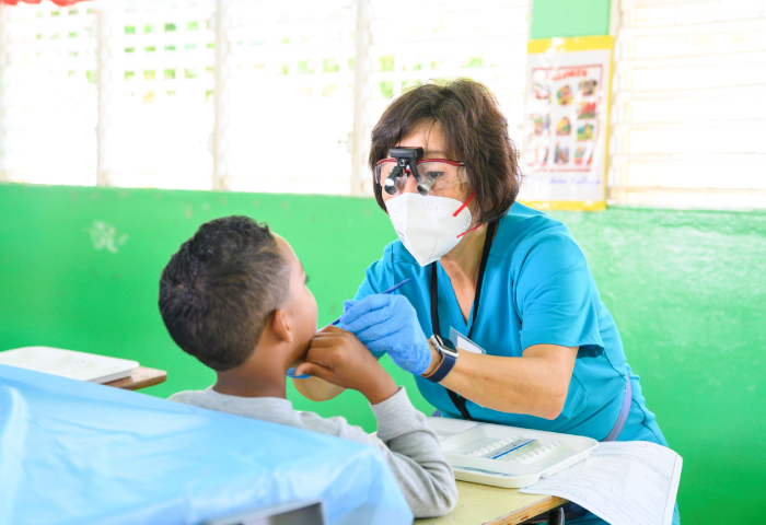 Envista employee performing dental assessment on mission trip